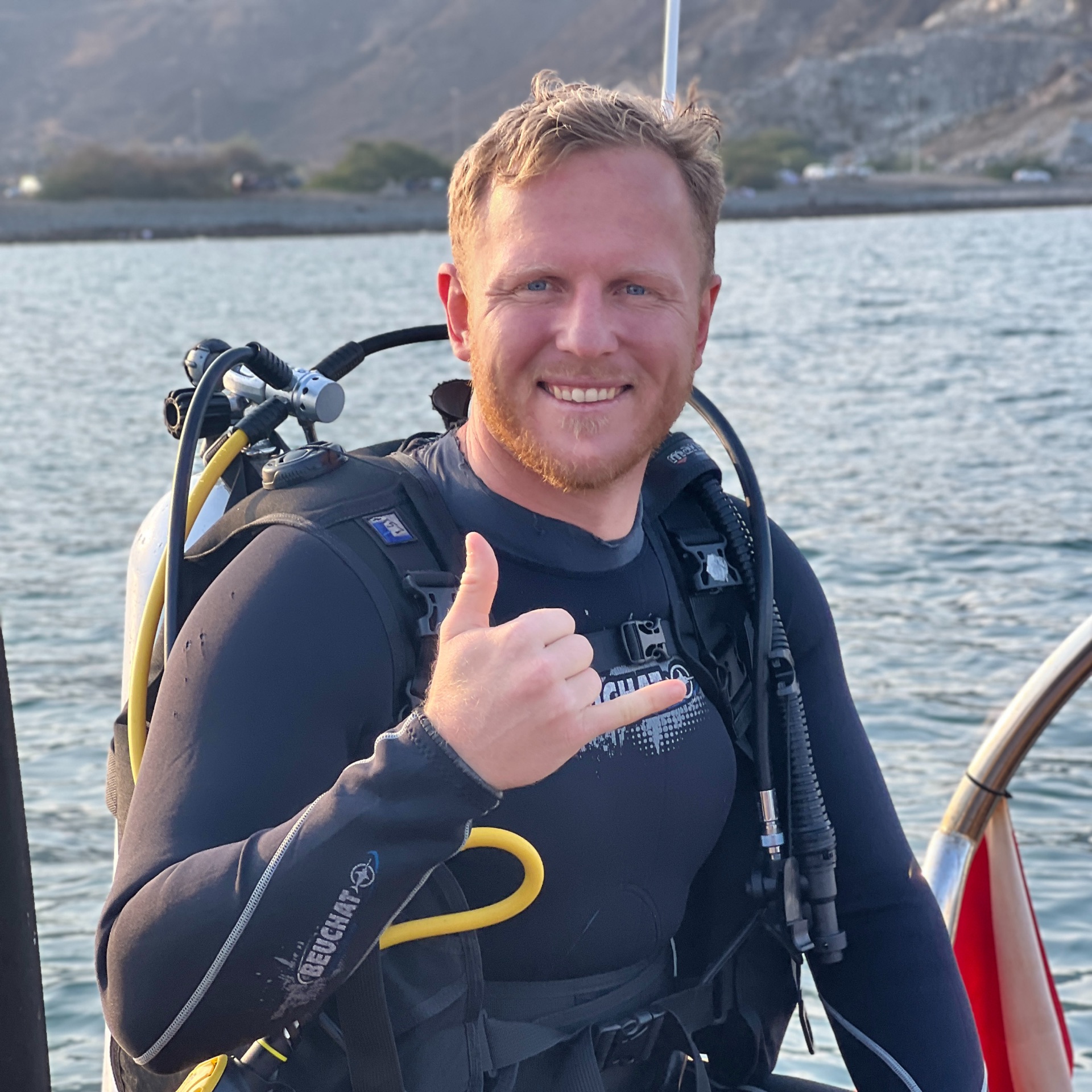 Lloyd Smith in dive gear giving a shaka
