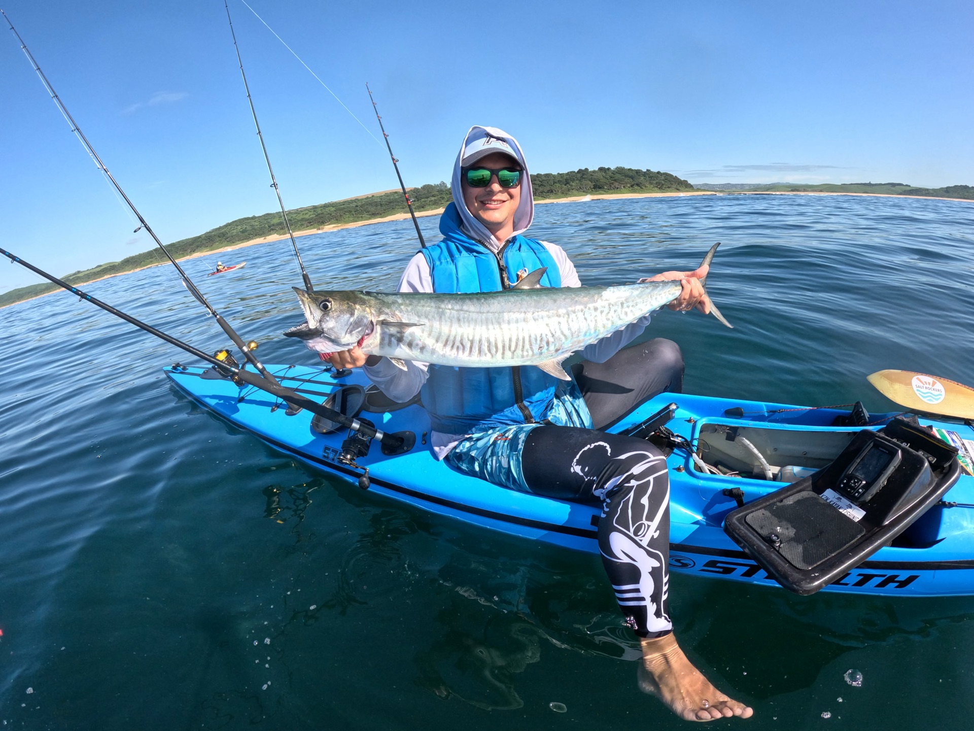 Salt Rockers crew member on a Stealth Pro Fisha kayak with a fish across his lap